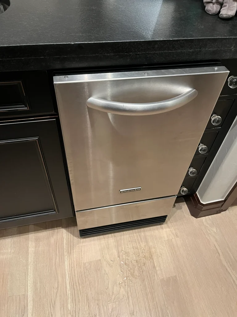 Stainless KitchenAid undercounter ice maker installed in a kitchen