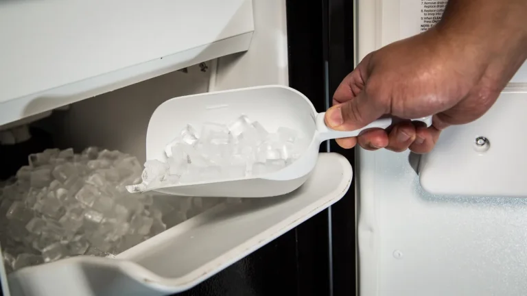 Hand scooping ice from an ice machine bin