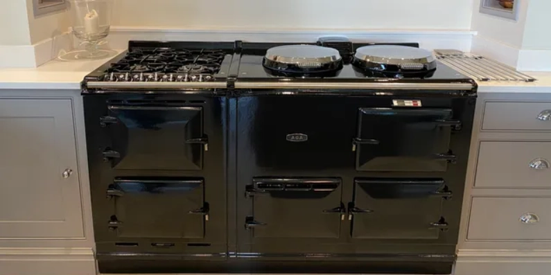 Black AGA range with multiple oven doors in a white kitchen.