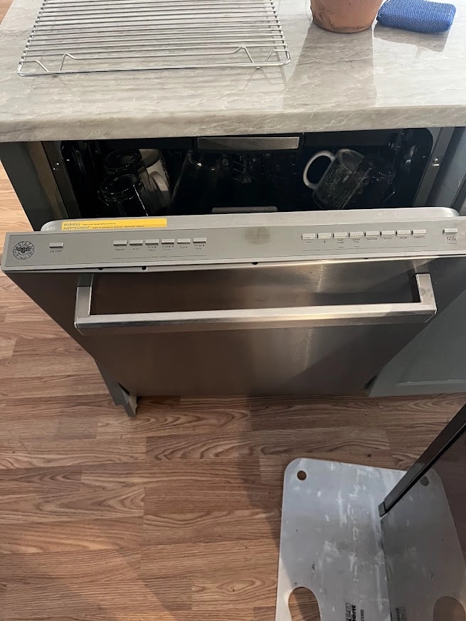 Bertazzoni dishwasher pulled out from beneath a kitchen counter.
