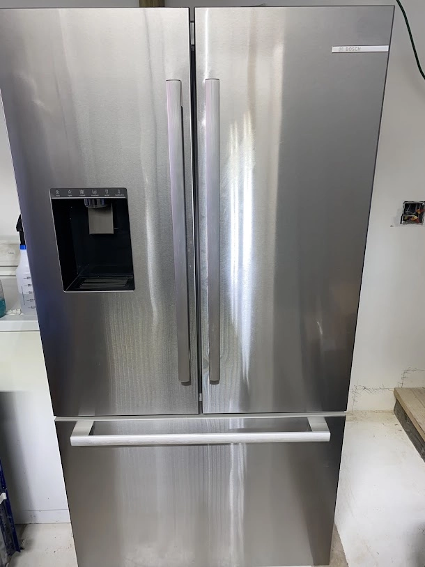 Stainless Bosch French door refrigerator with water dispenser.