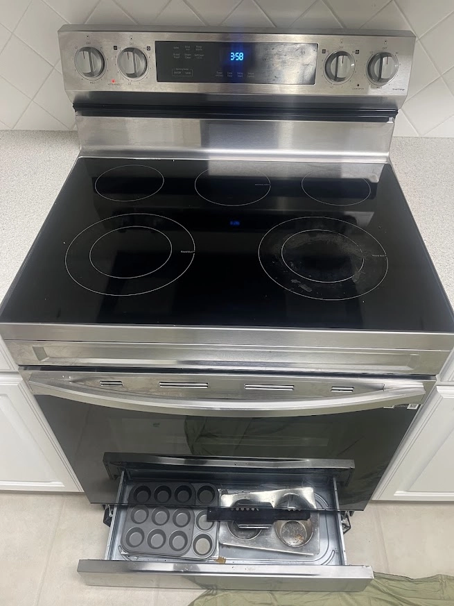 Bosch electric range with glass cooktop and open lower drawer.