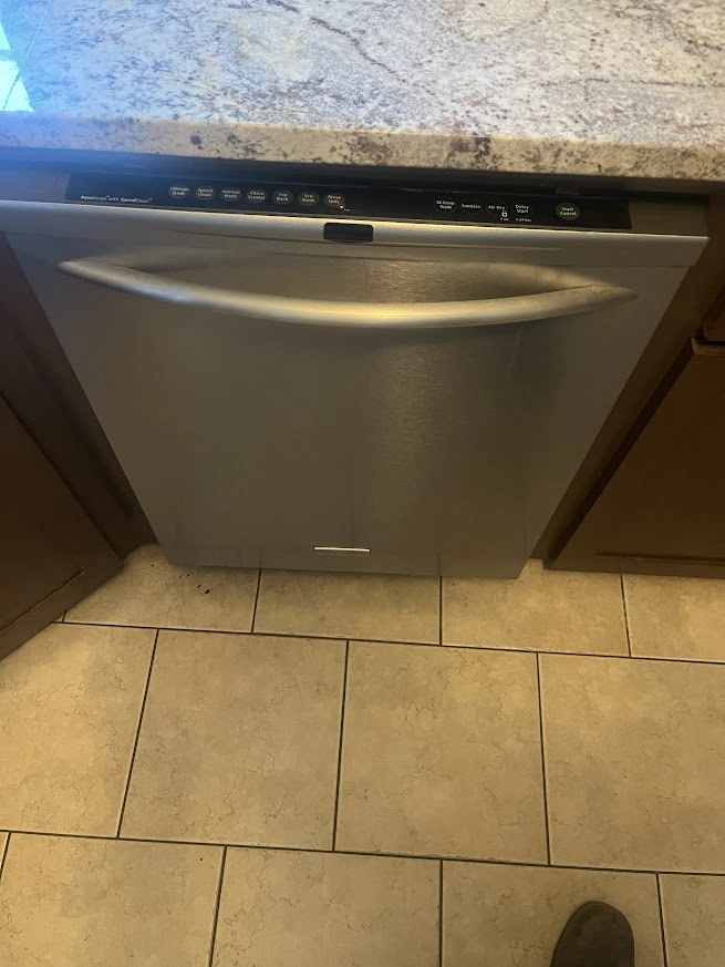 Stainless Frigidaire dishwasher beneath a granite countertop.