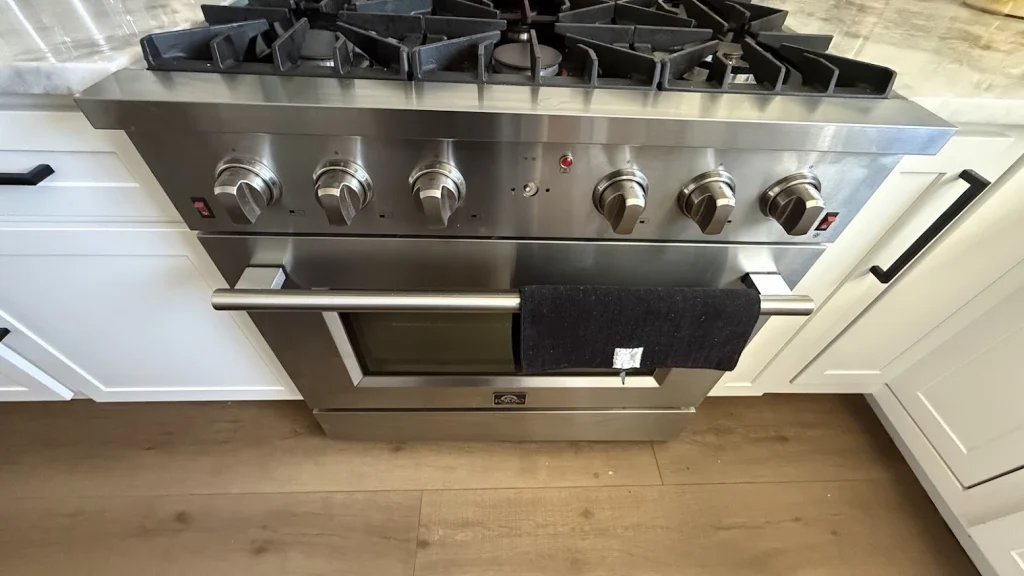 Stainless Forno gas range with oven in a white kitchen.