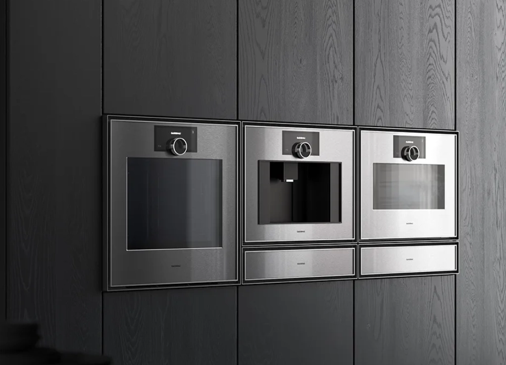Gaggenau built-in oven, coffee machine and steam oven in dark wood cabinetry