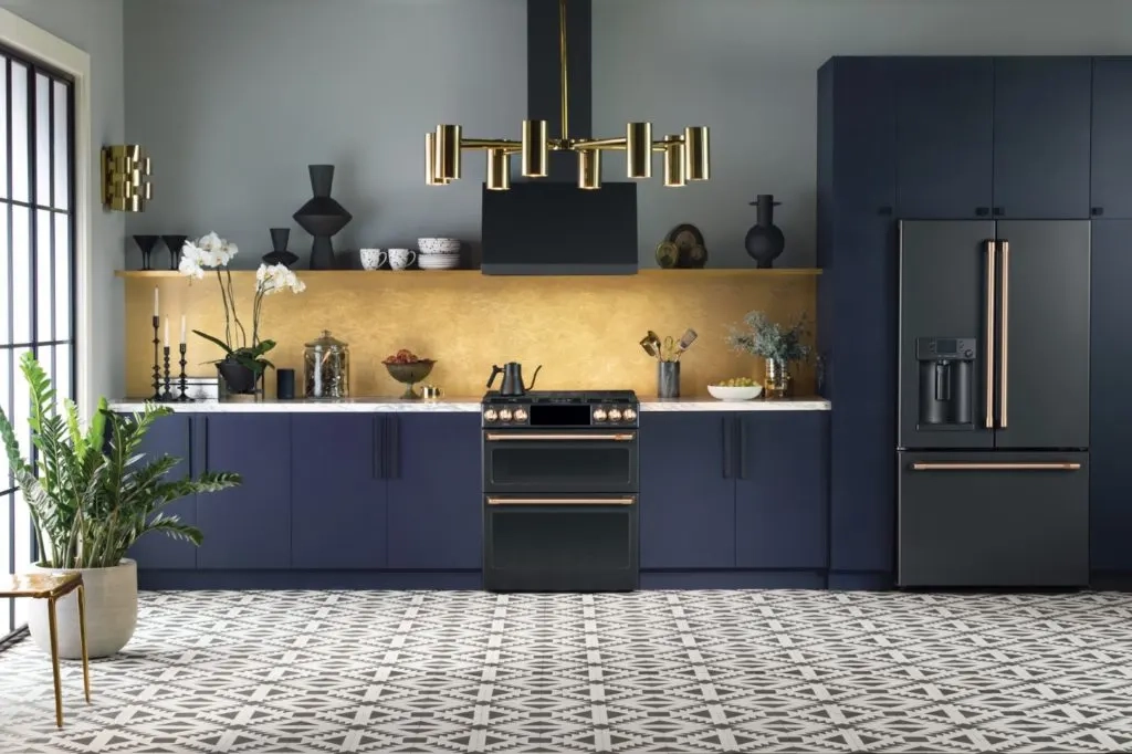 GE Appliance Repair in Edmond & Oklahoma City 8 Café range and refrigerator in a navy kitchen with brass accents.