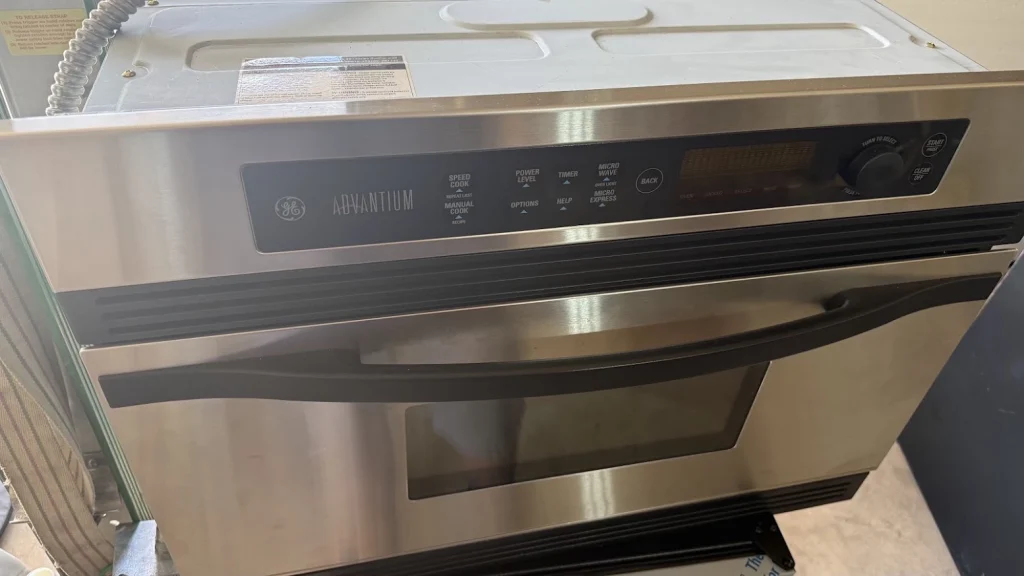 GE Appliance Repair in Edmond & Oklahoma City 6 Stainless GE microwave oven pulled partly out of cabinetry.