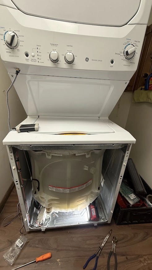 GE Appliance Repair in Edmond & Oklahoma City 5 Stacked GE laundry unit with lower front panel removed and drum exposed.