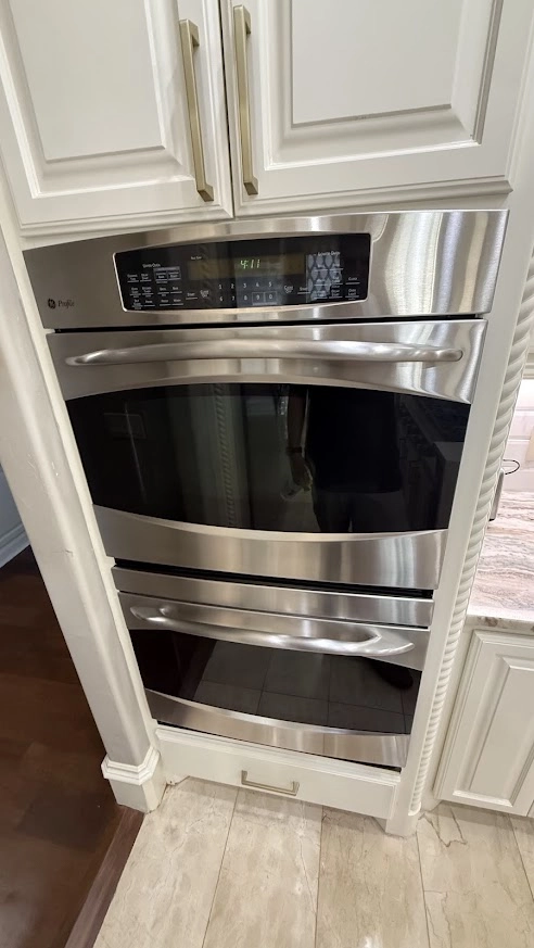 GE Appliance Repair in Edmond & Oklahoma City 2 Stainless GE double wall oven installed in white cabinets.