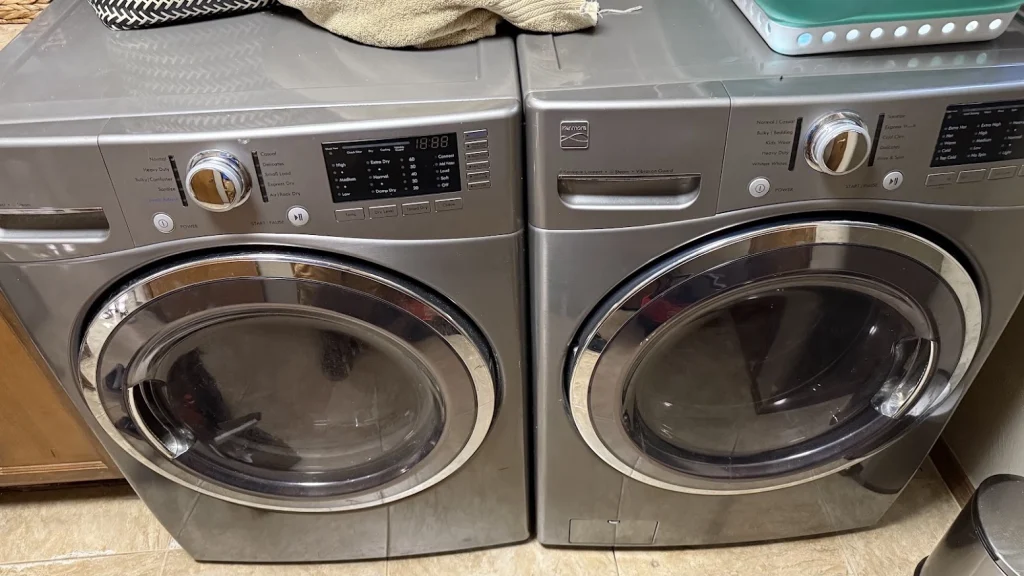 Silver Kenmore front load washer and dryer side by side.