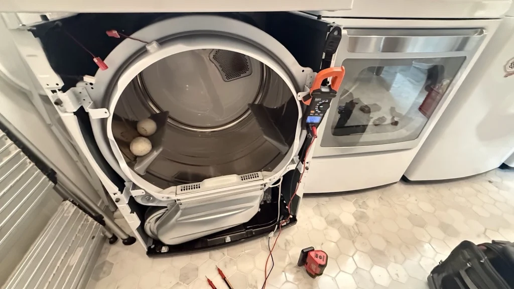 LG dryer with front panel removed, exposing the drum and wiring.