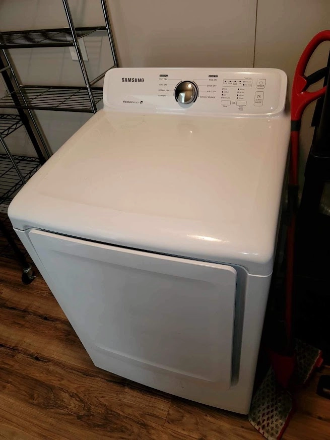White Samsung dryer in a laundry room.