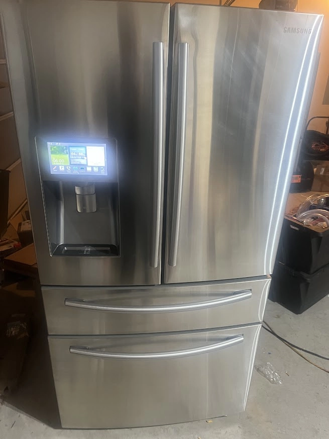 Stainless Samsung French door refrigerator with display on the door.