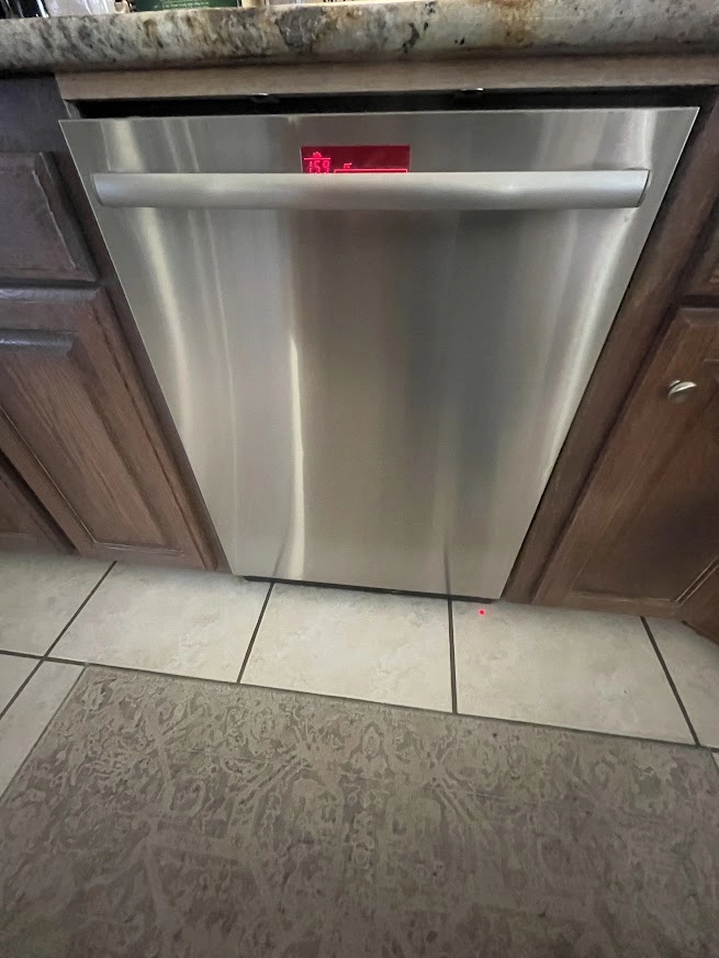 Stainless Thermador dishwasher beneath a stone countertop.