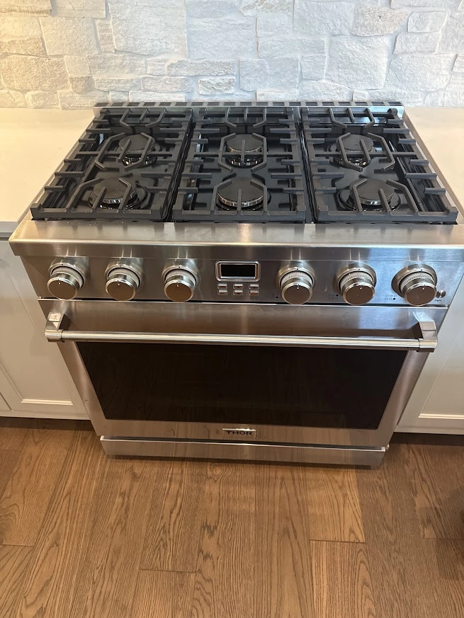 Stainless Thor gas range with oven and six burner cooktop.