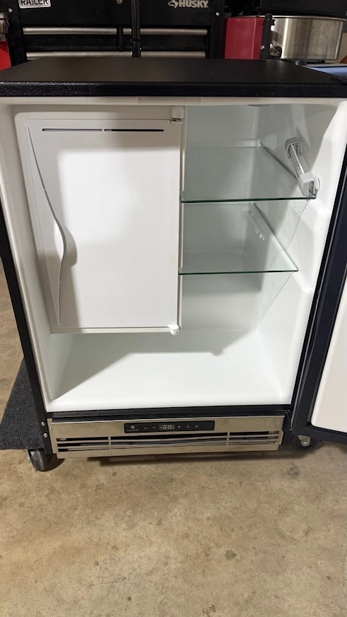 Open U Line undercounter refrigerator with empty shelves.