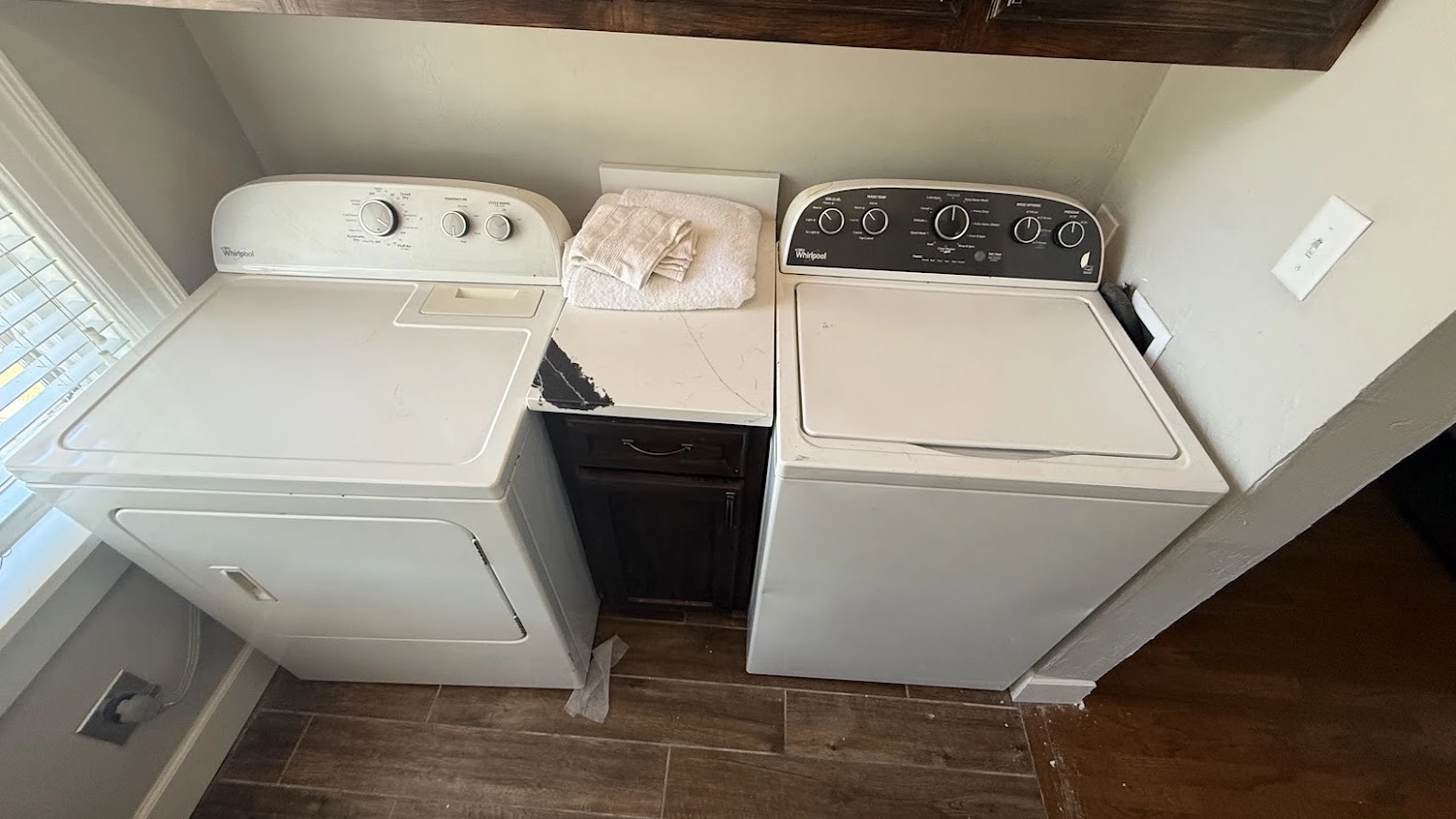 White Whirlpool washer and dryer in a laundry room.