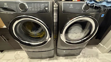 Black front-load washer and dryer under a counter.