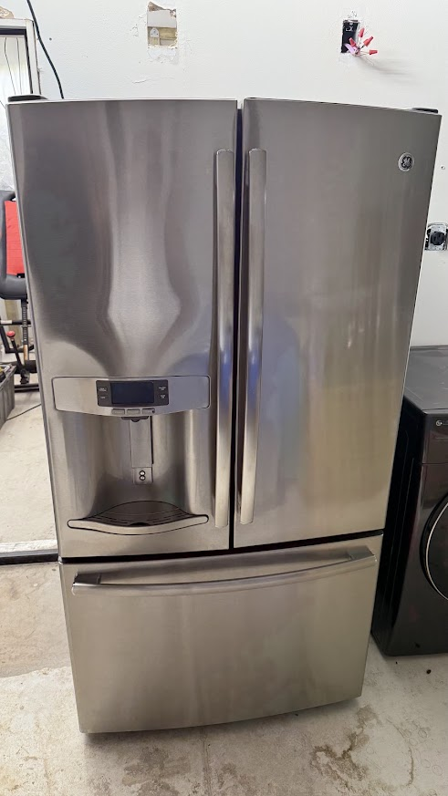 GE Appliance Repair in Edmond & Oklahoma City 4 Stainless steel GE French door refrigerator with a water dispenser and bottom freezer drawer in a workshop