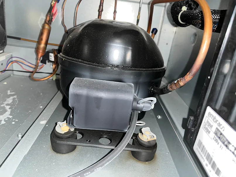 LG Refrigerator Not Cooling? 4 Things to Check First 1 LG refrigerator compressor with copper refrigerant tubing
