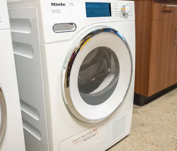 White Miele T1 heat pump dryer photographed from the front at an angle