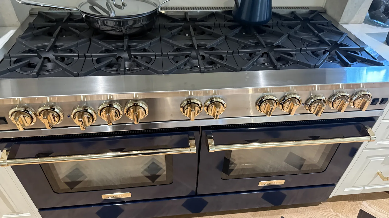BlueStar gas range with two ovens, cast iron burner grates and brass control knobs