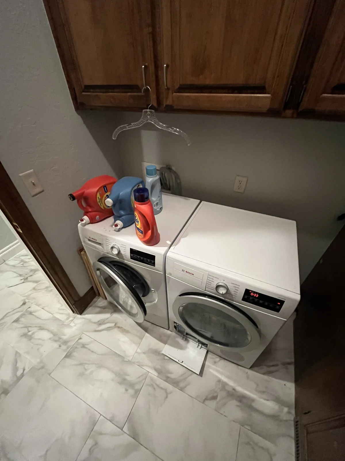 White Bosch washer and dryer with service equipment in a laundry room
