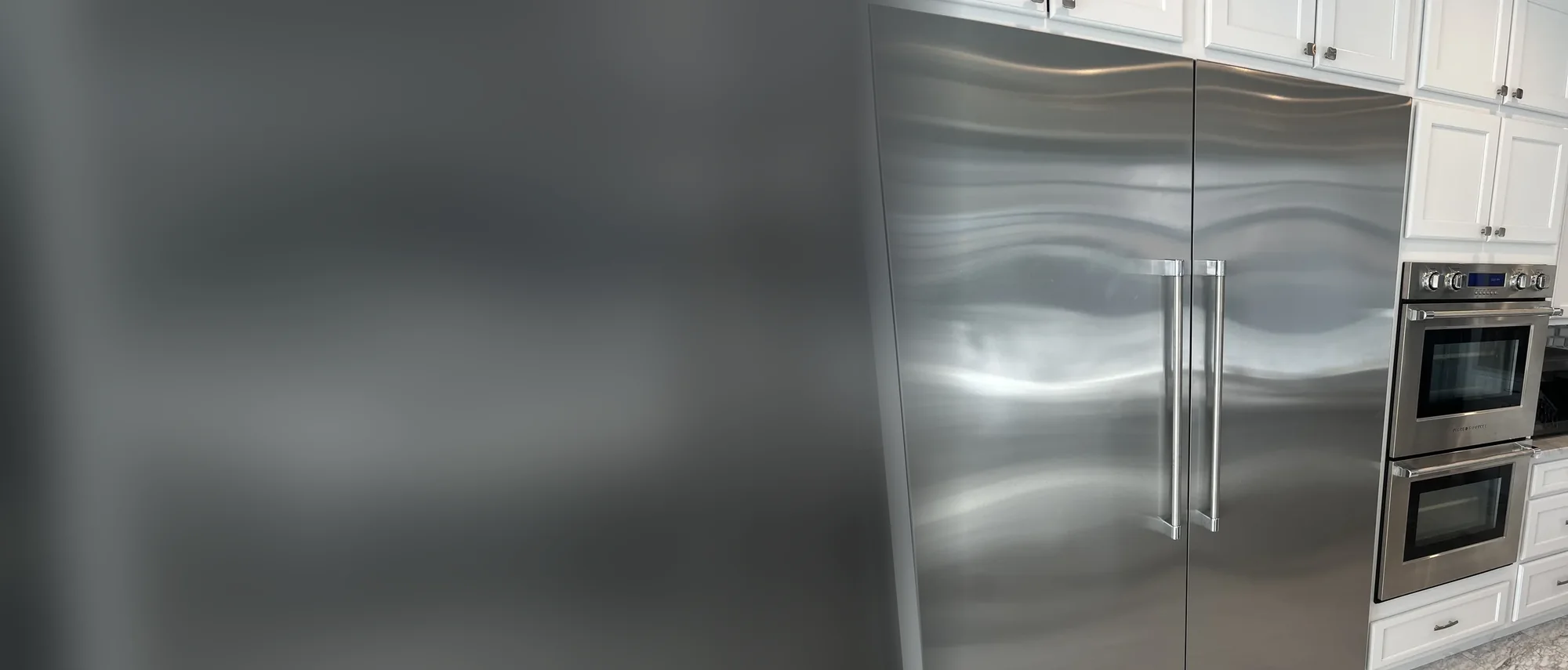 Fisher & Paykel built-in refrigerator next to double wall ovens