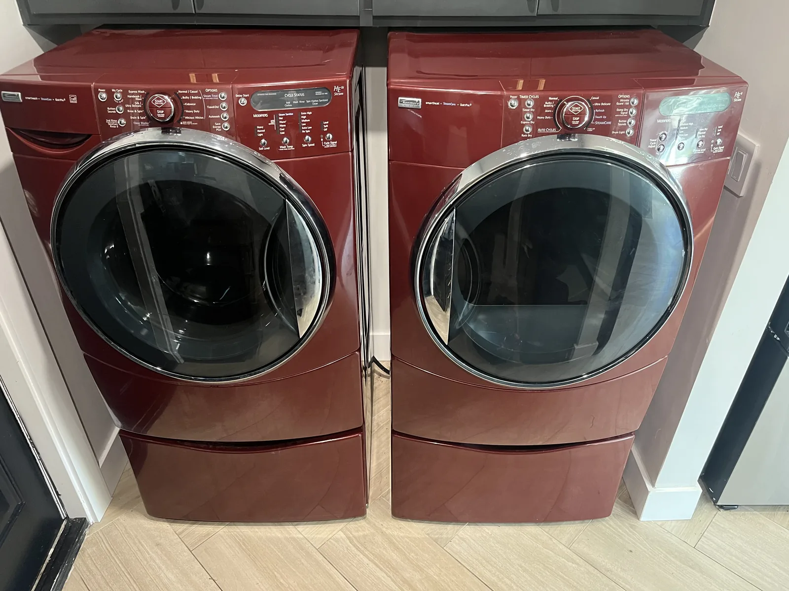 Red Kenmore front-load washer and matching dryer in a laundry room