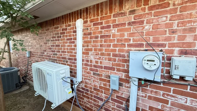Outdoor ductless mini split unit beside a brick building