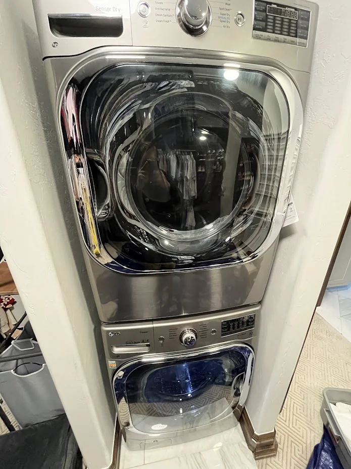 Stacked front-load washer and dryer in a narrow laundry space.