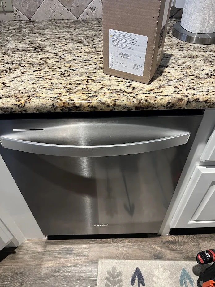Stainless dishwasher installed below a kitchen counter.