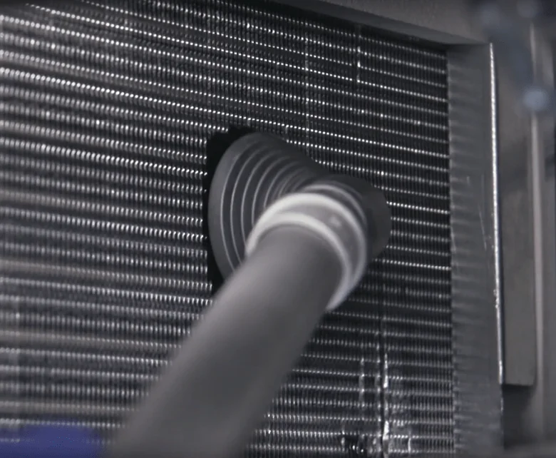 Vacuum attachment cleaning a refrigerator condenser coil