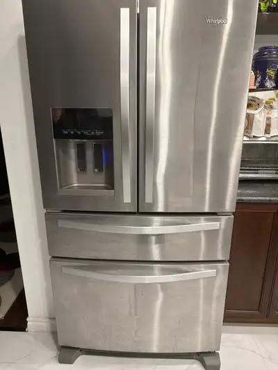 Stainless steel Whirlpool French door refrigerator with a door dispenser and two lower drawers