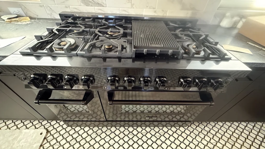 Wide stainless ZLINE gas range with two ovens and center griddle.